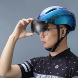 ROCKBROS blue cycling helmet with removable goggles worn by man adjusting visor.
