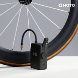 HOTO Electric Air Pump positioned beside bike tire with digital pressure display