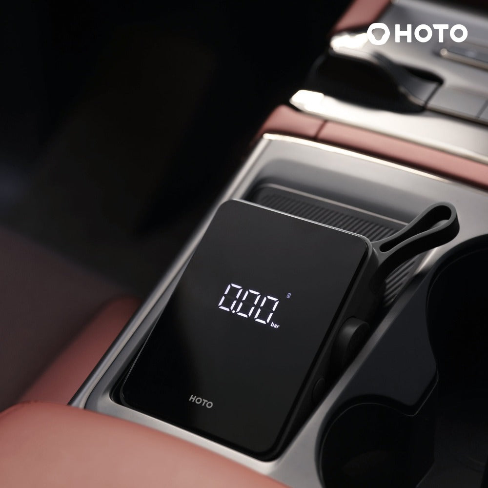 HOTO Electric Air Pump displaying 0.00 bar pressure in a car console.
