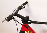 Close-up of Bike Adapter Pro on handlebars of red mountain bike for secure transport.