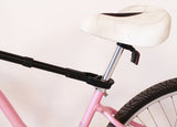 Bike Adapter Pro attached to a pink bicycle's seat post for secure transport.