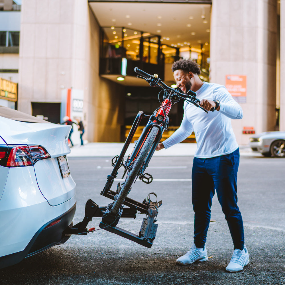 Man loading red electric bike onto Destination E hitch bike rack