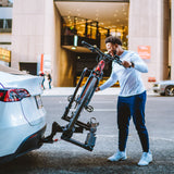 Man loading red electric bike onto Destination E hitch bike rack