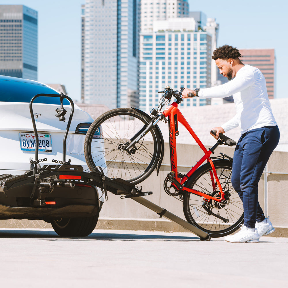 Man loading red electric bike onto Destination E hitch rack