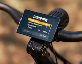 Close-up of the display on the handlebars of a Velotric Nomad 2X fat tire ebike, with the "Stealth Mode" setting option highlighted on the screen